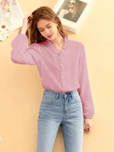 Damen lässige rosa Rüschen V-Ausschnitt Langarmbluse kombiniert mit klassischer blauer Jeans.