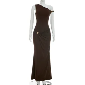 Détail de la robe longue marron asymétrique avec boucle métallique élégante et froncement.