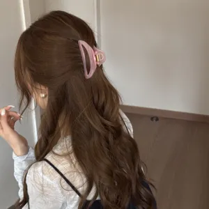 Pink hollow curved medium hair claw clip for elegant daily hairstyles, secure and stylish accessory.