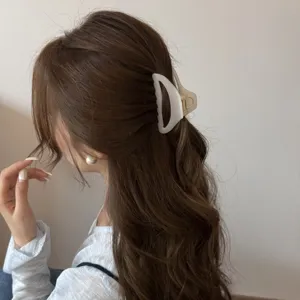 Hollow curved medium hair claw clip for elegant hairstyles, solid grip hairpin for women.