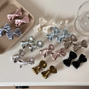 Detailed shot of multi-color satin bow hair clips set, cute hair accessories for girls.