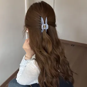 Detail view of a hollow curved hair claw clip worn on long hair, stylish and secure grip.