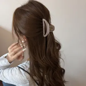 Hollow curved medium hair claw clip for women, elegant minimalist hair accessory styling tool.