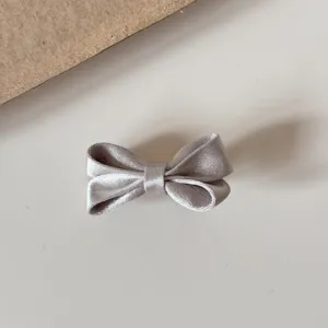 Silver satin bow hair clip detail, featuring a glossy fabric design for cute daily hairstyles.