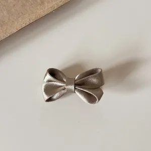 Close-up of satin bow hair clip, shiny texture, delicate craftsmanship, ideal for daily hairstyles.