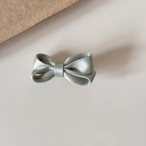 Silver satin bow hair clip detail, cute mini hair accessory for girls and kids daily styling.