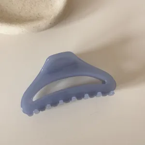 Close-up detail of the blue translucent hollow curved hair claw clip for elegant hairstyles.