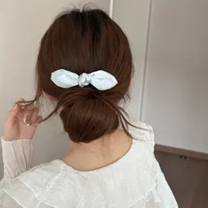 Light blue satin bow hair clip detail view showing elegant back hair styling accessory.
