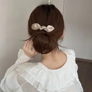 Elegant satin bow hair clip detail view, featuring a smooth finish and secure hold for chic styling.