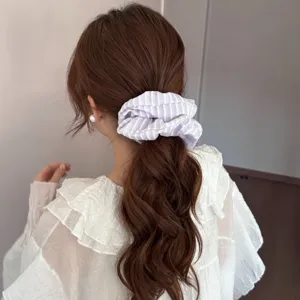 Gedetailleerd overzicht van de gestreepte stoffen haarband, met textuur en paardenstaart-look.