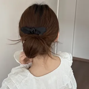 Black bow hair comb insert detail view showcasing elegant hair accessory styling and secure grip.