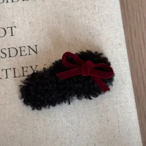 Nahaufnahme Detail einer süßen Herbst Winter Plüsch Haarklammer mit roter Samtschleife.