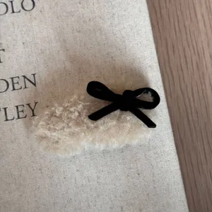 Nahaufnahme einer flauschigen Schleifen-Haarspange mit weichem Plüsch und schwarzer Schleife.
