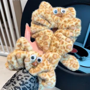 Detailed view of fluffy leopard print cat hair scrunchie with cute googly eyes for daily wear.