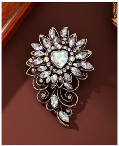 Close-up shot of vintage rhinestone heart flower brooch with intricate metal filigree.