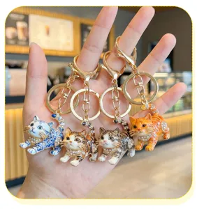 Detail shot of cute cat keychains with rhinestones and blue porcelain pattern for bags.