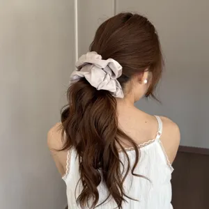 Elegant satin hair scrunchie detail shot showcasing soft texture and fluffy volume for styling.