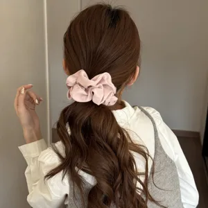 Pink satin hair scrunchie detail view, soft silk ponytail holder for women daily hair styling.
