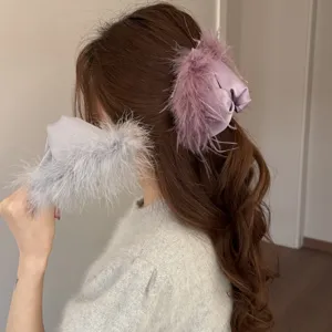 Feather hair claw clip detail shot showcasing soft fuzzy plush texture and elegant style.