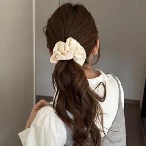 Elegant beige satin scrunchie for women, soft hair tie and daily styling hair accessory.