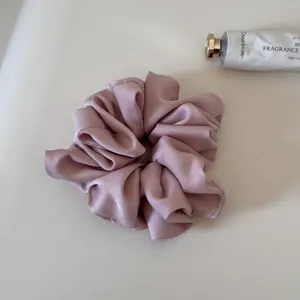 Pink satin hair scrunchie with soft fabric and high elasticity, perfect for daily styling.