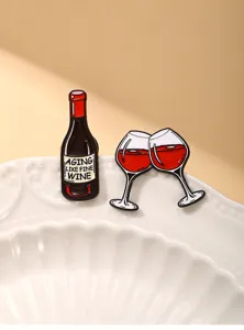 Primo piano dettagliato di spille smaltate bottiglia di vino e bicchieri con citazione.