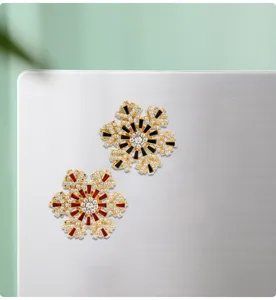 Detalle del pasador magnético de copo de nieve de cristal con pedrería brillante.
