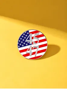 Close-up detail shot of the US flag metal pin featuring 45 47 numbers, glossy enamel texture.