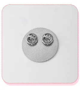Metal brooch pin back view showing double butterfly clutches and textured round base design.