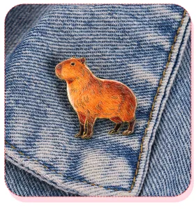 Dettaglio della graziosa spilla in metallo capibara per decorazione zaini e vestiti casual