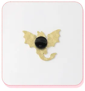 Detailed view of the back of a dragon metal brooch pin with secure rubber clutch back.