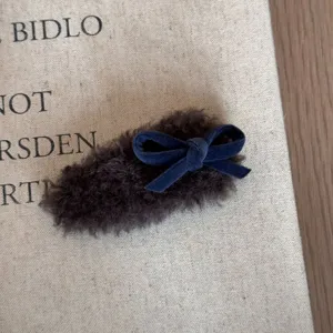 Braune flauschige Haarspange mit dunkelblauer Samtschleife, weiche Textur und süßer Stil.