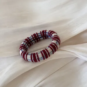 Detalle de coletero de punto, accesorio con patrón de cuadros rojo blanco y azul para peinados bonitos.