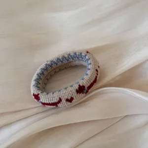 Coletero de punto vista de detalle con bonitos corazones rojos y geométricos motivos.