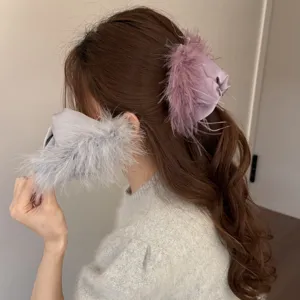 Detailed view of elegant fluffy feather hair claw and matching plush accessory for women.
