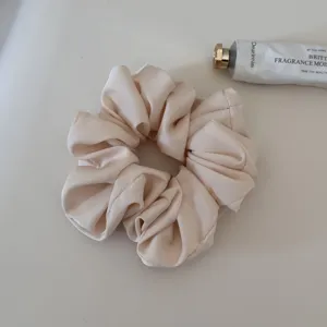 Soft satin hair scrunchie for women, elegant daily hair tie ponytail holder in light beige.
