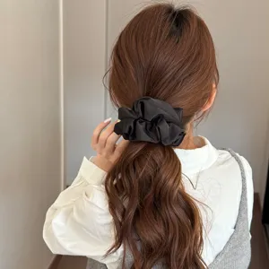 Elegant black satin hair scrunchie for women, premium everyday elastic ponytail holder accessory.