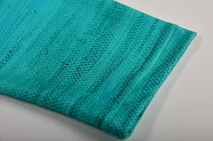 Detailed view of the teal floral long sleeve top cuff, showing fine stitching and fabric texture.