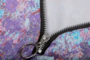 Detail view of women's floral V-neck long sleeve top zipper and fabric texture.