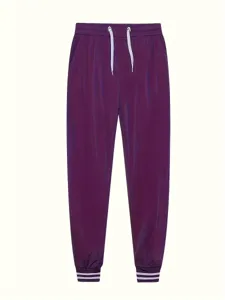 Dettaglio di pantaloni della tuta viola con coulisse bianca e polsini a righe.