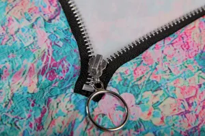 Close-up detail of women colorful floral long sleeve top zipper hardware texture showcase