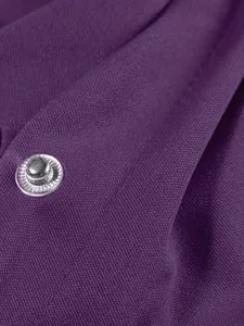 Vista dettagliata del tessuto viola e del bottone automatico in metallo per giacca casual donna.