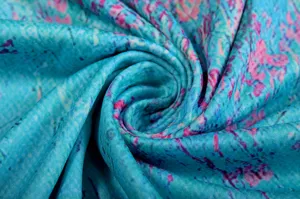 Detailed view of blue fabric with pink floral print, showcasing soft texture and spiral fold.