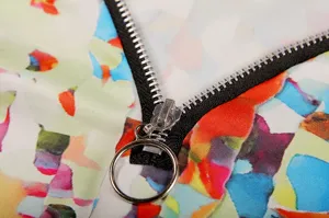 Close-up detail of colorful floral print women top zipper and soft fabric texture.