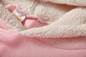 Détail de loungewear polaire rose d'hiver avec doublure sherpa blanche, tissu chaud doux.