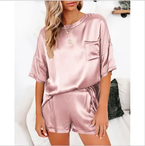 Roze satijnen korte pyjama set detail met handige zak en zachte zijdezachte textuur.
