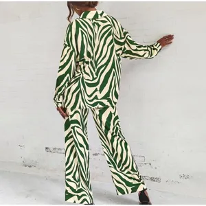 Vue de detail de la chemise elegant imprimee zibree vert et blanc et de son pantalon.