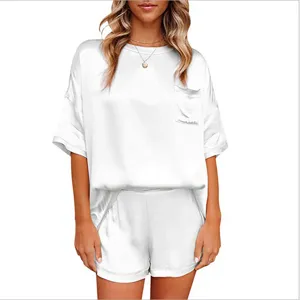 Detail van witte zijde-achtige pyjamaset, korte mouw top met zak en comfortabele short.