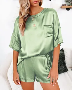 Lichtgroene satijnen pyjama set detail met korte mouw top en bijpassende shorts voor dames.