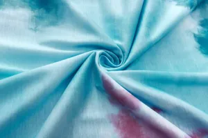 Tie dye fabric detail shot showing abstract blue and pink swirl pattern textile material.